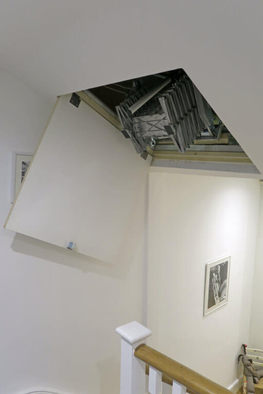 Elite loft ladder fitted behind an angled loft hatch in a sloping ceiling Elite loft ladder fitted behind an angled loft hatch in a sloping ceiling